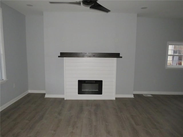 unfurnished living room featuring dark hardwood / wood-style floors and ceiling fan