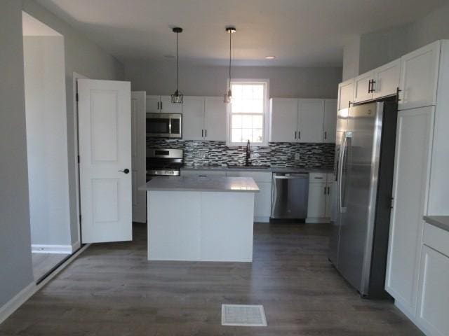 kitchen featuring visible vents, dark wood-type flooring, tasteful backsplash, appliances with stainless steel finishes, and white cabinets