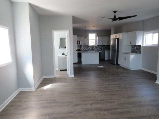 kitchen with a wealth of natural light, white cabinets, open floor plan, and appliances with stainless steel finishes