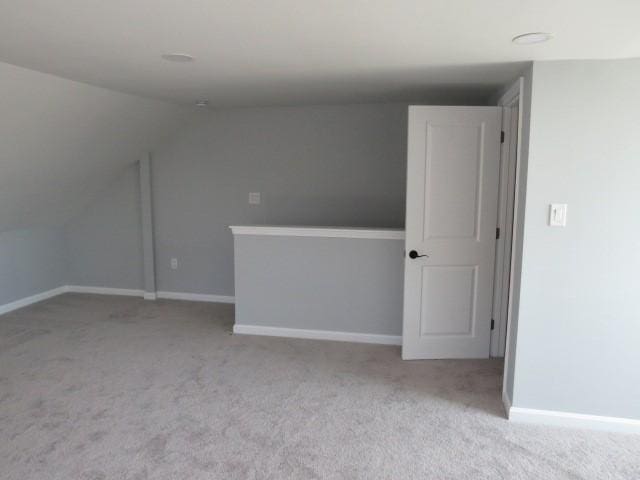 additional living space featuring carpet flooring, baseboards, and lofted ceiling