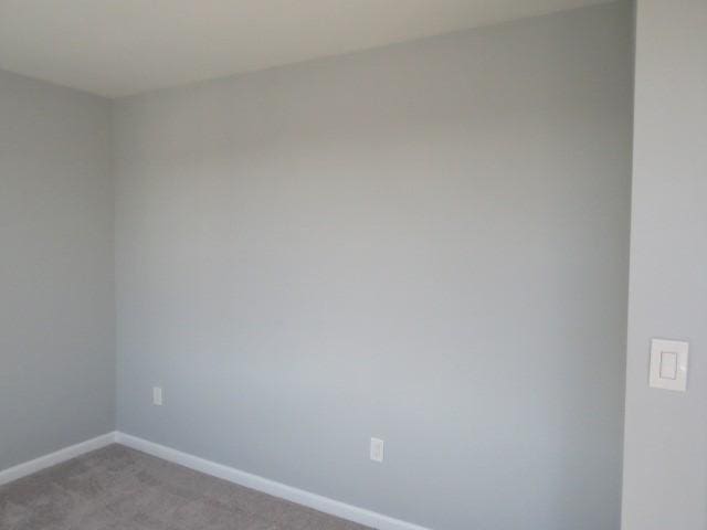 unfurnished room with light colored carpet and baseboards