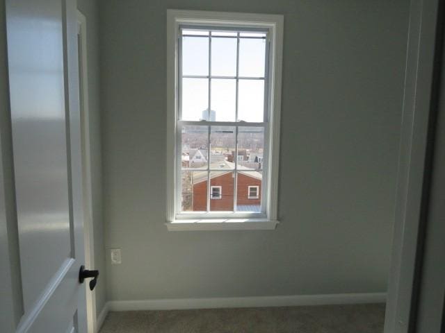 spare room featuring a healthy amount of sunlight and baseboards