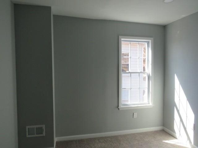 carpeted spare room with baseboards and visible vents