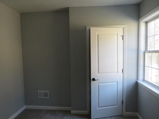 unfurnished room featuring visible vents and baseboards