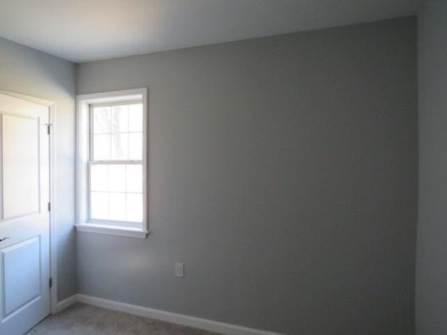 unfurnished room featuring baseboards and light colored carpet