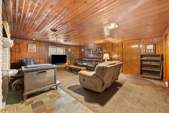 living room with light carpet, a wood stove, wooden ceiling, and wood walls