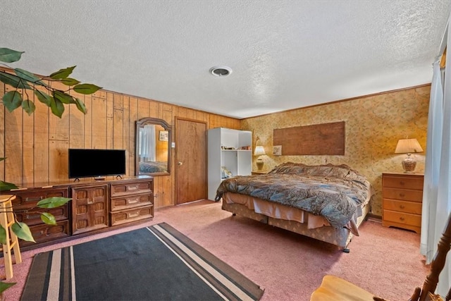 carpeted bedroom with wooden walls and a textured ceiling