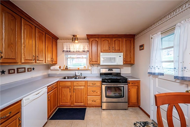 kitchen with sink, light tile patterned floors, and white appliances