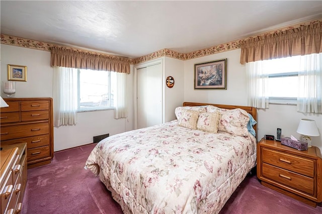 bedroom featuring a closet and dark colored carpet