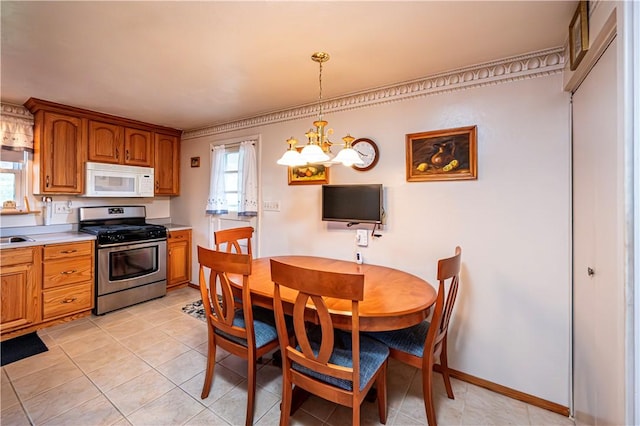 kitchen featuring a chandelier, stainless steel gas range oven, a wealth of natural light, and pendant lighting