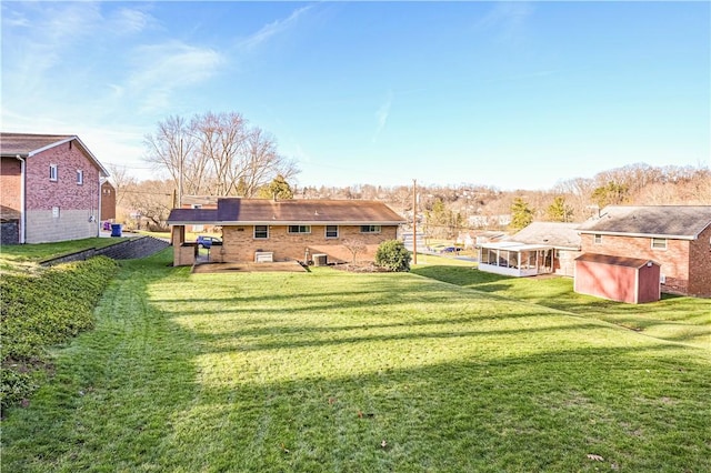 view of yard with central AC, a sunroom, and an outdoor structure