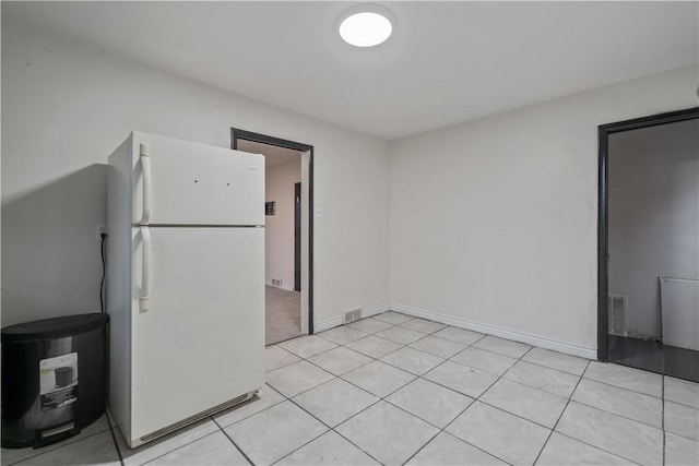 kitchen featuring white fridge and light tile patterned flooring