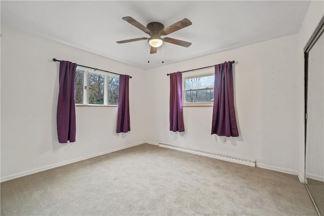 spare room featuring carpet, a baseboard radiator, a wealth of natural light, and ceiling fan