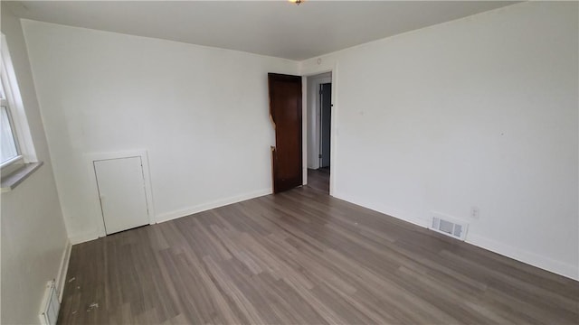 unfurnished room featuring dark wood-type flooring