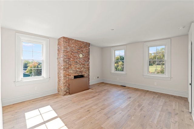 unfurnished living room featuring a fireplace and light hardwood / wood-style flooring