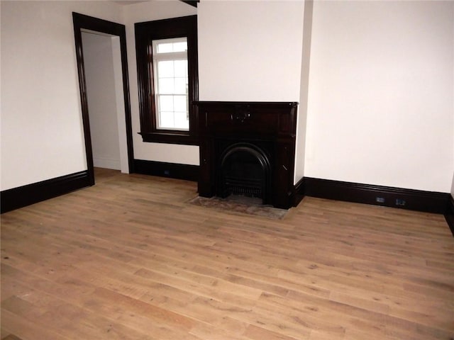 unfurnished living room with a fireplace and light hardwood / wood-style flooring