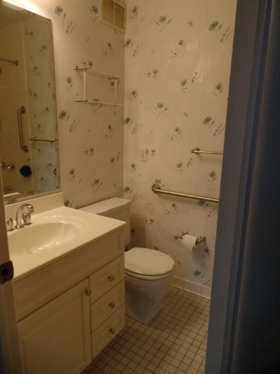 bathroom with tile patterned flooring, vanity, and toilet