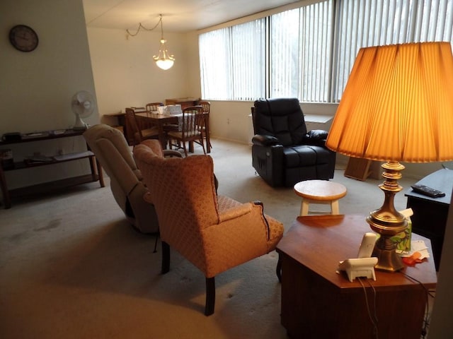 carpeted living room featuring an inviting chandelier