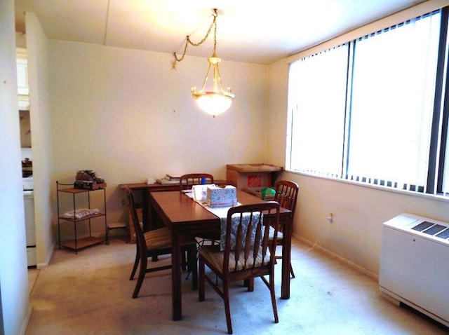 dining area with light carpet and radiator heating unit