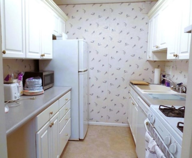 kitchen with white cabinetry, sink, and gas range gas stove