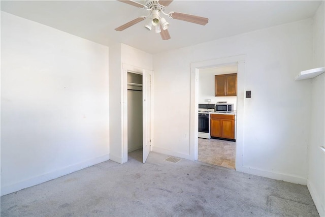 unfurnished bedroom featuring ceiling fan, a closet, and light colored carpet