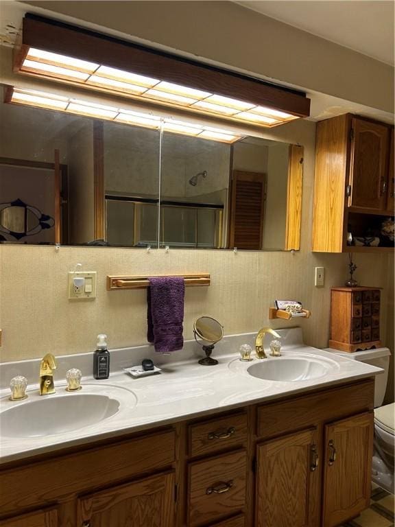 bathroom featuring vanity, toilet, and a shower with door