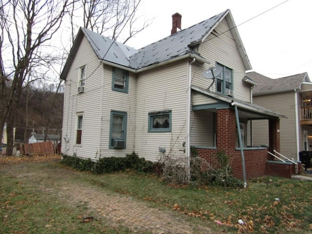 view of side of property with a lawn and covered porch