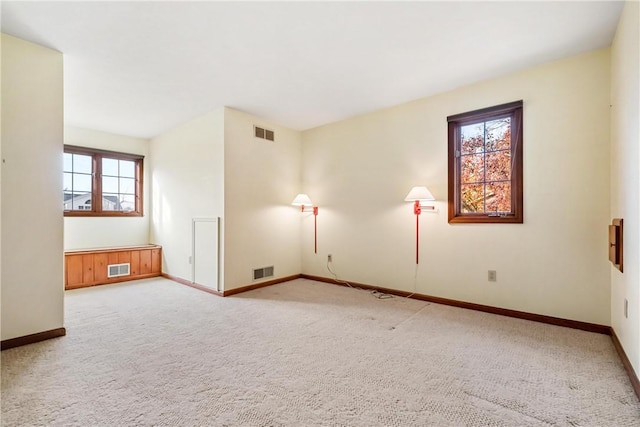 carpeted spare room featuring plenty of natural light