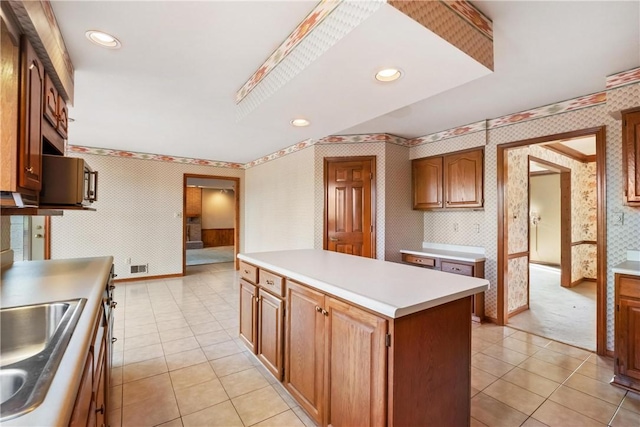 kitchen featuring light tile patterned floors, a center island, and sink