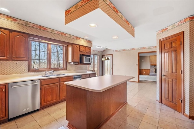 kitchen with a center island, sink, tasteful backsplash, light tile patterned flooring, and stainless steel appliances