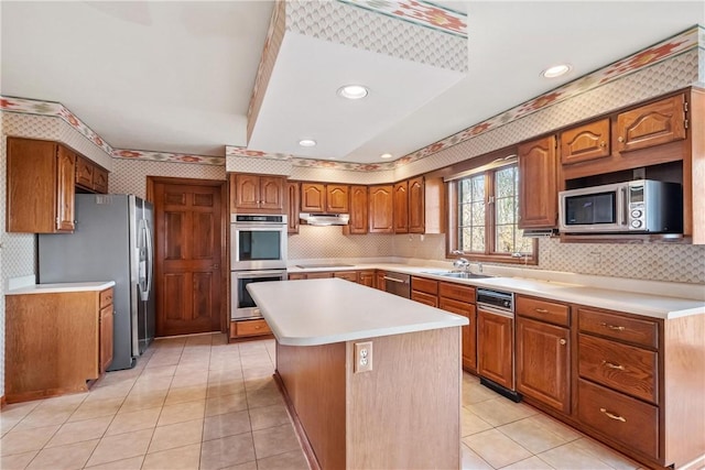 kitchen featuring sink, tasteful backsplash, light tile patterned flooring, a kitchen island, and appliances with stainless steel finishes