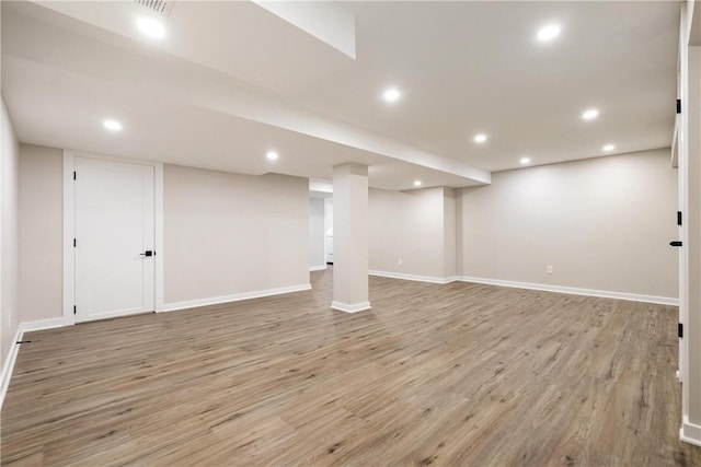 basement with light hardwood / wood-style flooring