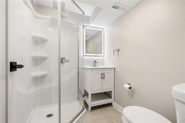 bathroom with vanity, toilet, and a shower with shower door