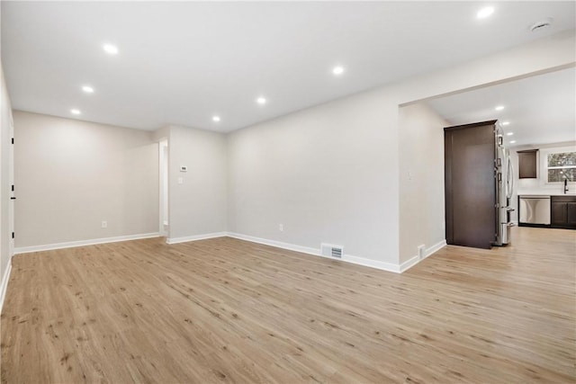 unfurnished room featuring light hardwood / wood-style floors and sink