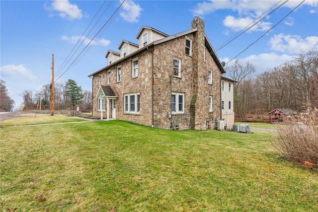 back of property featuring a lawn and central AC unit