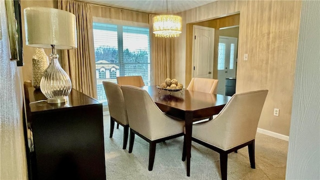 carpeted dining area featuring an inviting chandelier