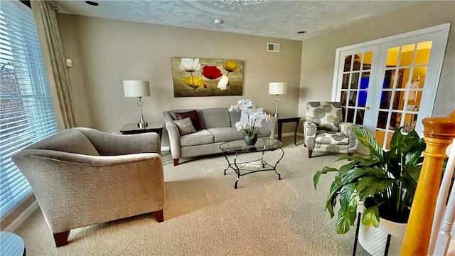 carpeted living room featuring french doors and a textured ceiling