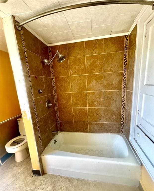 bathroom featuring tiled shower / bath combo and toilet