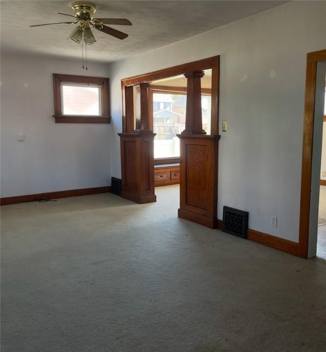 carpeted spare room featuring plenty of natural light and ceiling fan