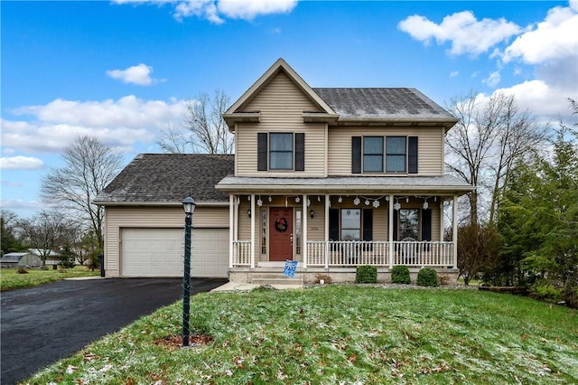 view of front of home featuring covered porch, a garage, and a front yard