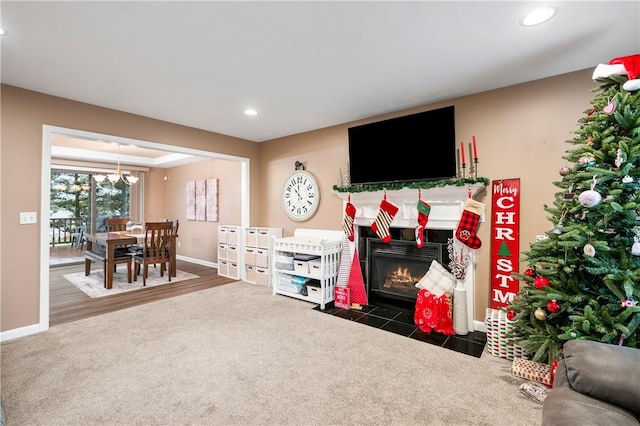 living room with hardwood / wood-style floors, a tile fireplace, and a chandelier