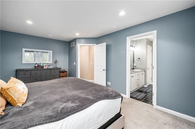 bedroom with dark carpet, sink, and ensuite bath