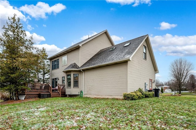 rear view of house featuring a lawn and a wooden deck