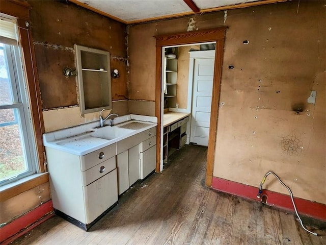 kitchen with white cabinets, wood-type flooring, a healthy amount of sunlight, and sink