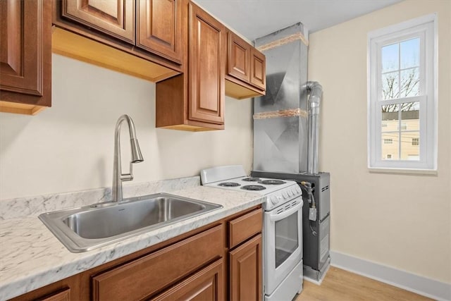 kitchen featuring white range with electric cooktop, light hardwood / wood-style floors, light stone counters, and sink