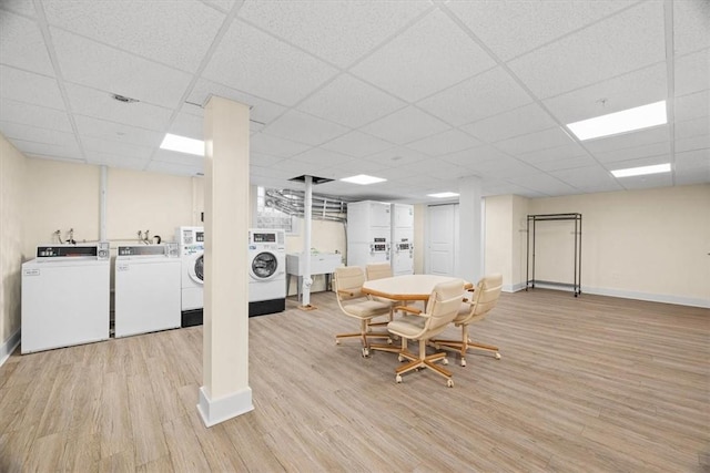 interior space with washing machine and dryer, a paneled ceiling, and light hardwood / wood-style flooring