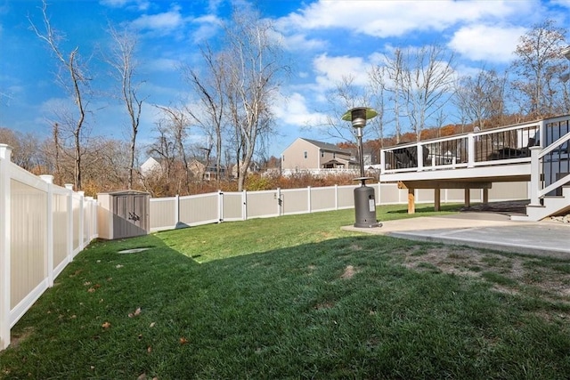 view of yard with a patio area, a shed, and a wooden deck