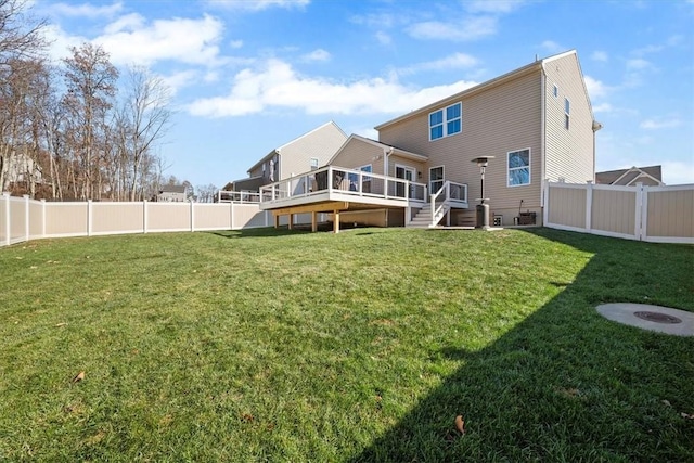 rear view of house featuring a lawn and a deck