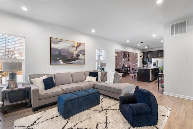 living room with light hardwood / wood-style floors and sink