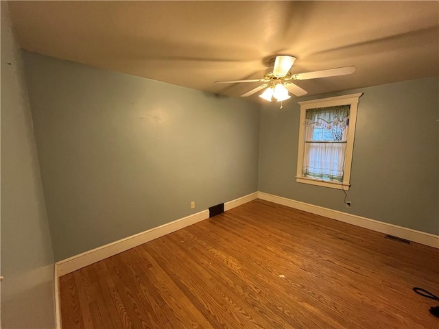 spare room featuring wood-type flooring and ceiling fan